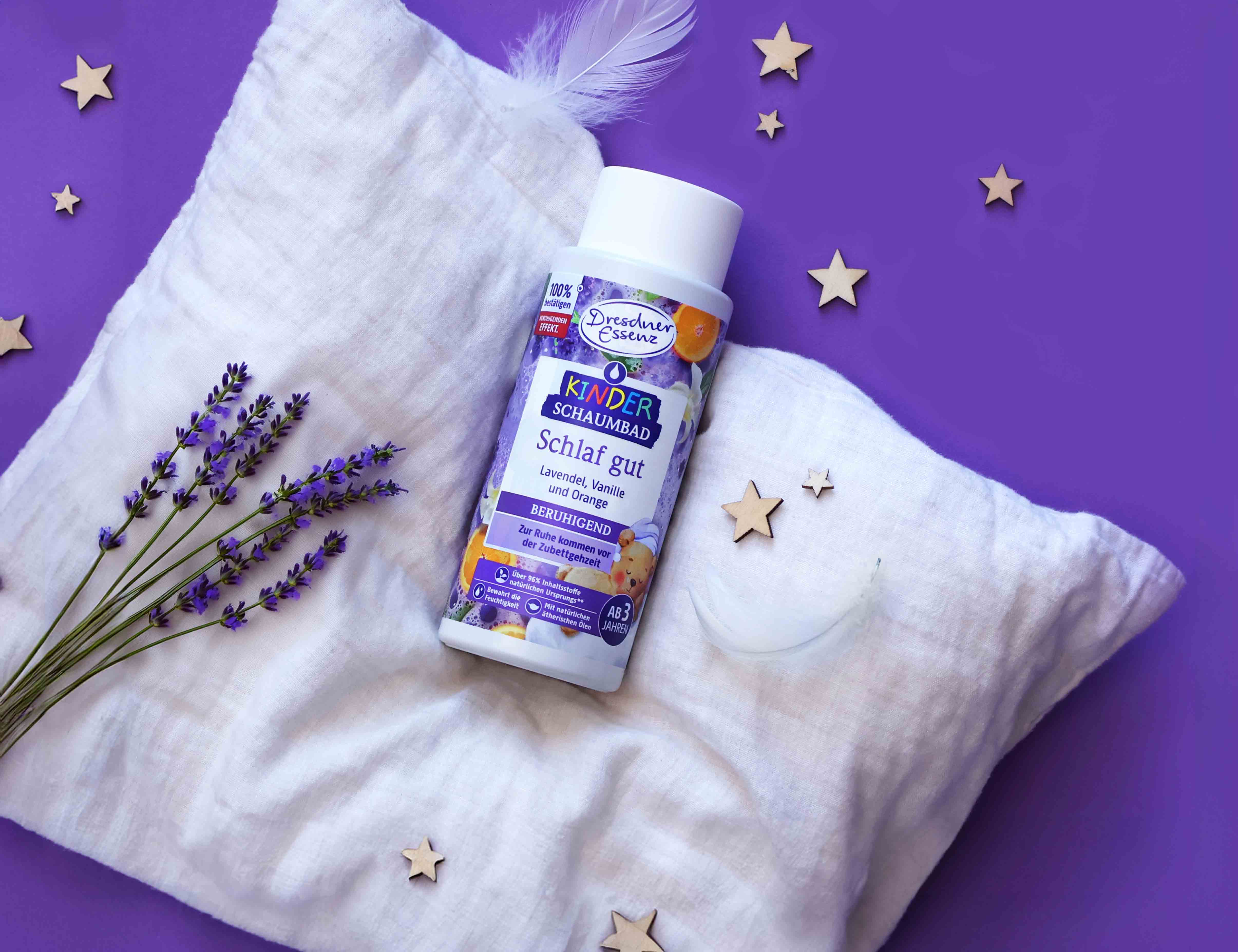 Das Kinder-Schaumbad Schlaf gut liegt auf einem weichen Kissen und ist mit Lavendel und kleinen Sternchen dekoriert.