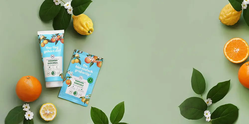Naturkosmetik Produkte auf grünem Untergrund mit Orangen und Yuzun