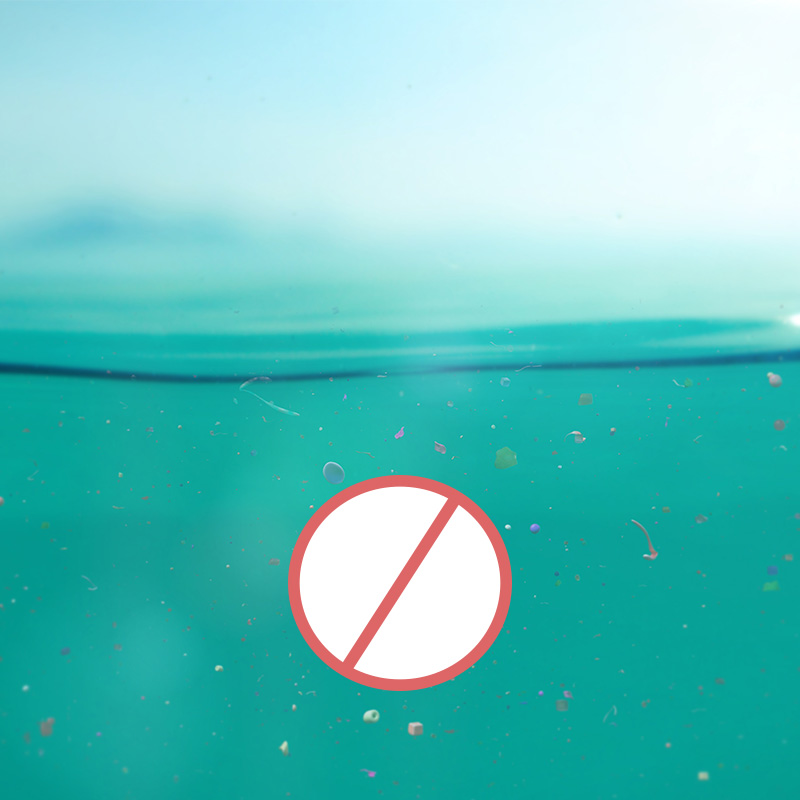 Nahaufnahme von Wasser, in dem kleine Mikroplastikteilchen schwimmen; zusaetzlich ist ein Symbol eines roten durchgestrichenen Kreises abgebildet