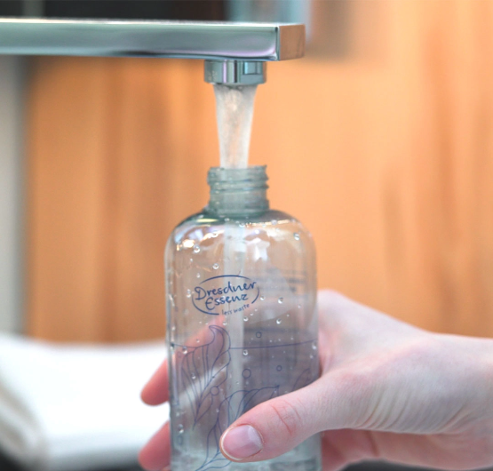 Anleitung fuer die Pulverkonzentrate: Wasser wird in die wiederverwendbare Flasche gefuellt