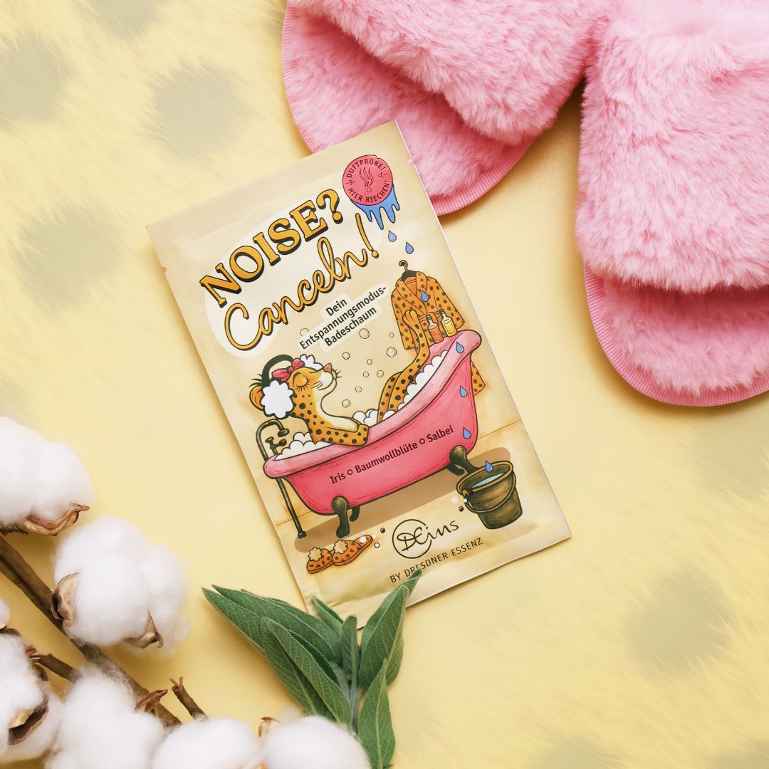 Der Badeschaum liegt im Fokus zwischen Baumwollblueten und Salbei