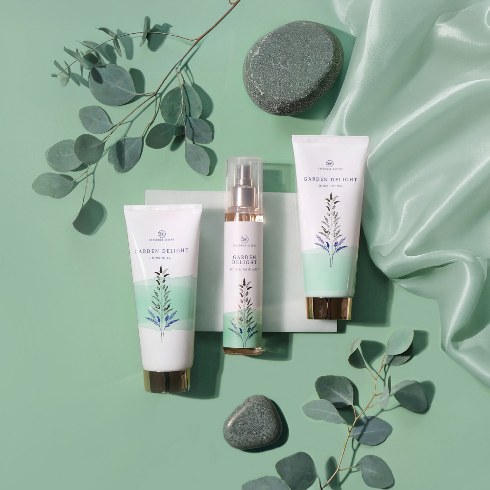 Garden Delight Produkte liegen nebeneinander und sind umgeben von Blaettern, Steinen und eleganten Stoffen
