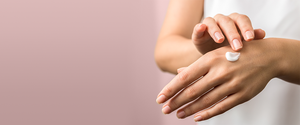 Nahaufnahme einer Hand, die mit einer Handcreme eingecremt wird