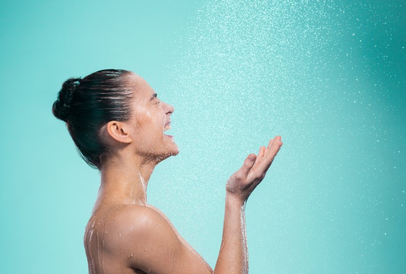 Frau lachend unter einer Dusche