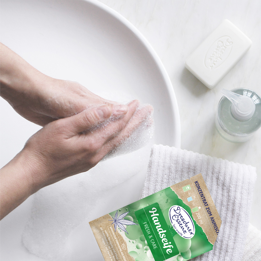 Handseife Pulver liegt neben einem Waschbecken und eine Person waescht sich die Haende