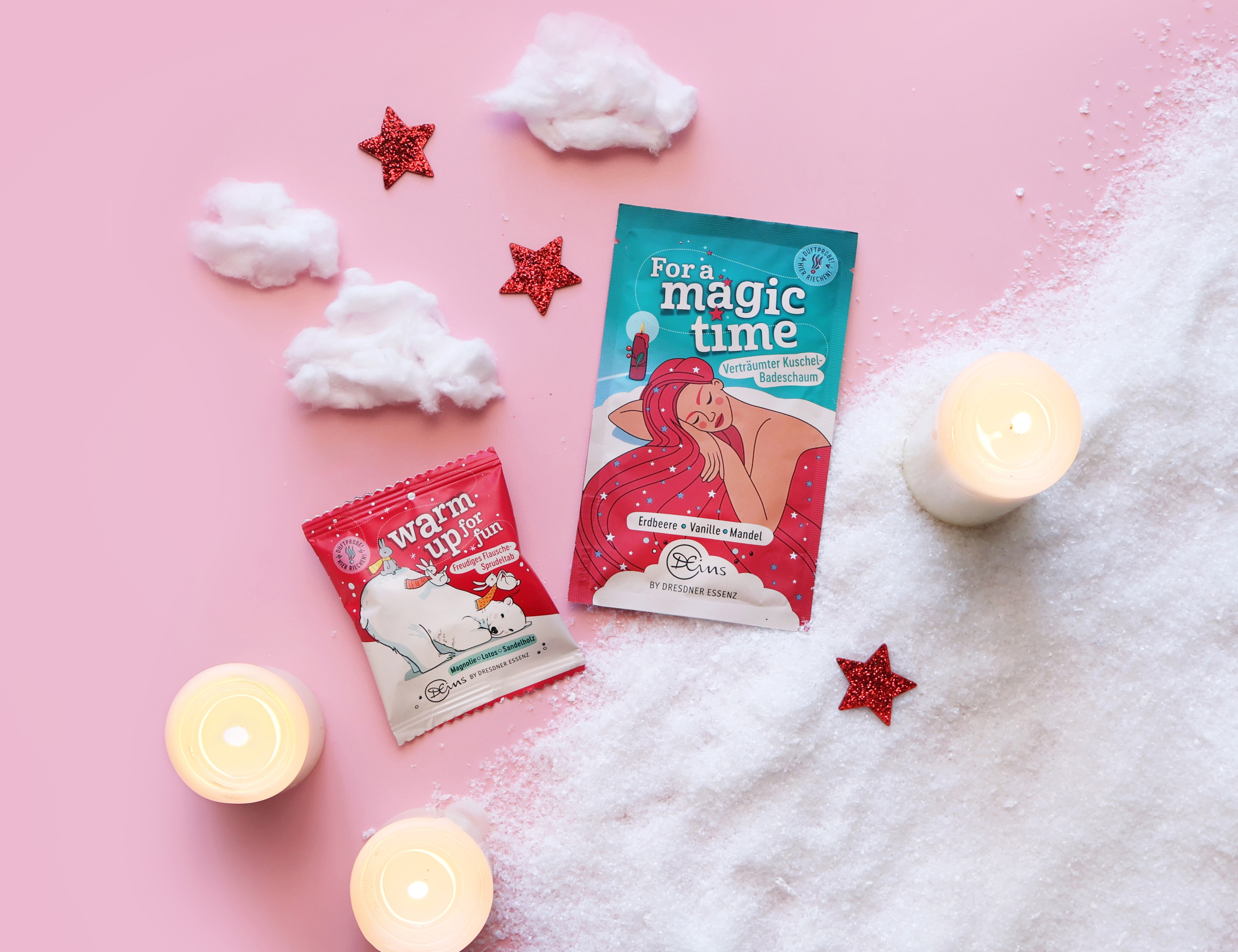 Der Badeschaum For a magic time und der Sprudeltab Warm up for fun liegen in einer kuscheligen Kulisse mit flauschiger Watte und gemütlichen Kerzen.