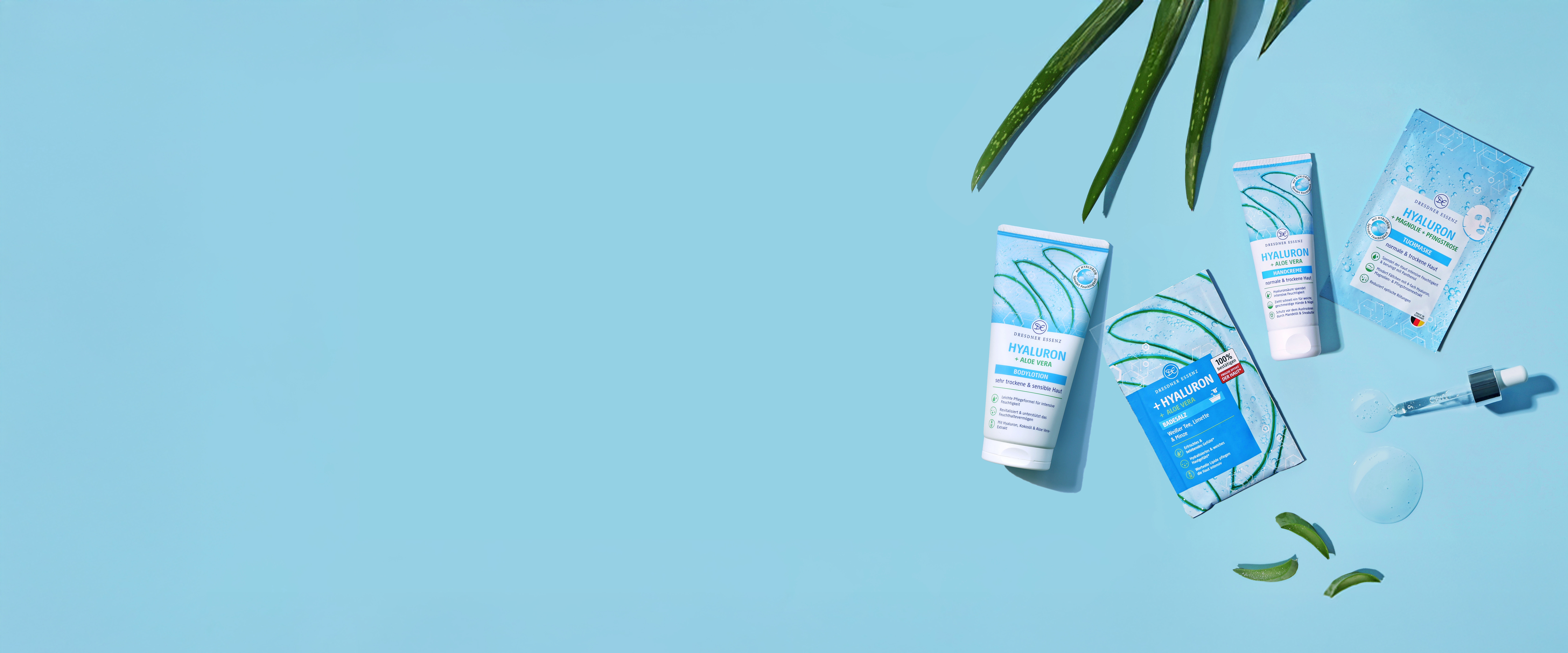 Die Produkte Badesalz, Tuchmaske, Handcreme und Bodylotion aus der Hyaluron Serie liegen nebeneinander und drum herum liegen dekorativ verschiedene Pflanzen und eine Pipette.