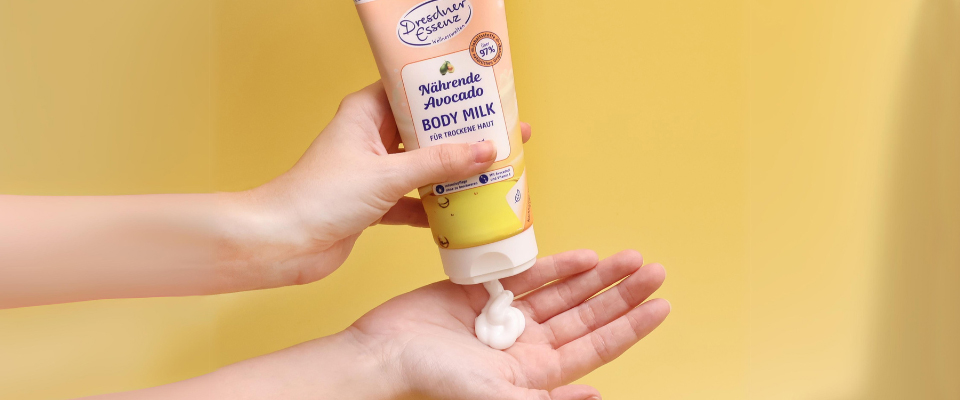 Die Bodylotion Naehrende Avocado wird in eine Handflaeche gegeben.